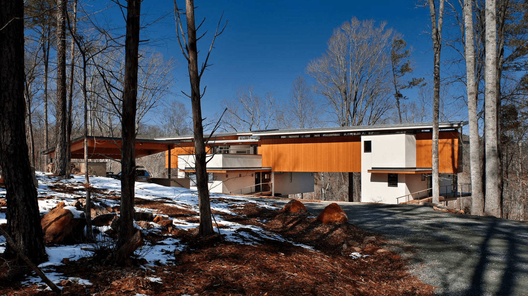 a house in the woods surrounded by snow