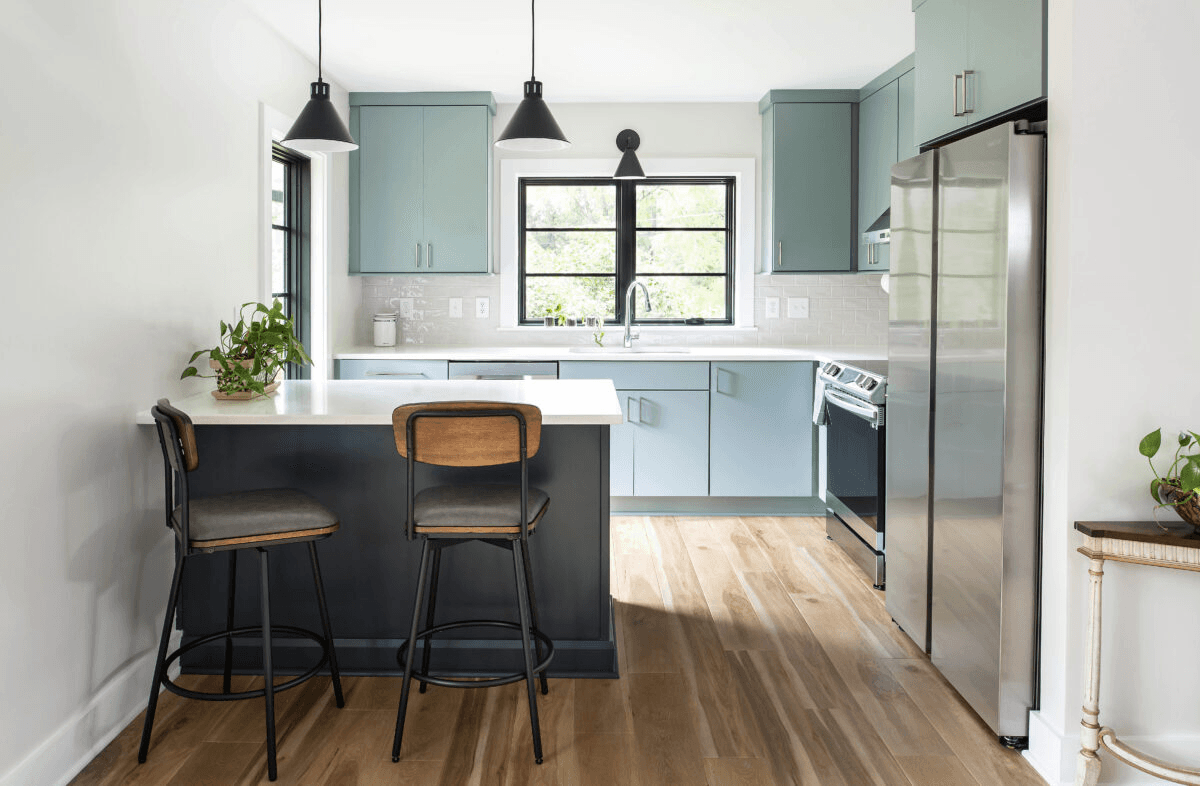 a kitchen with two stools next to an island